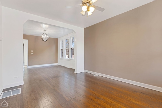 unfurnished room with dark wood-type flooring and ceiling fan with notable chandelier