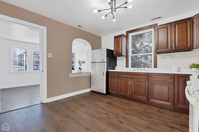 kitchen featuring range with electric stovetop, backsplash, stainless steel fridge, and dark hardwood / wood-style floors