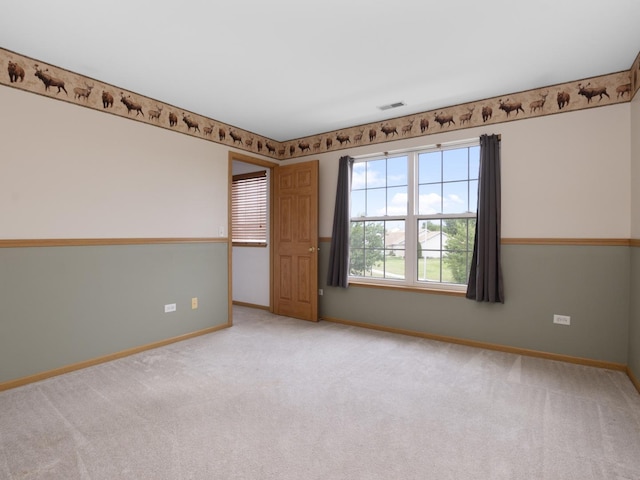 carpeted empty room featuring visible vents and baseboards