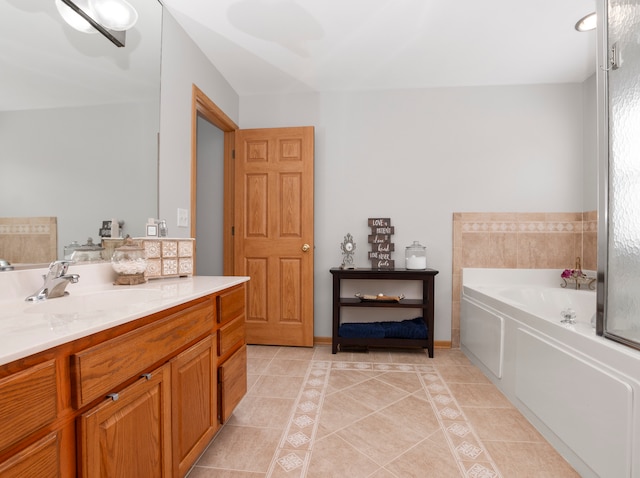 bathroom with a washtub, vanity, and tile patterned floors