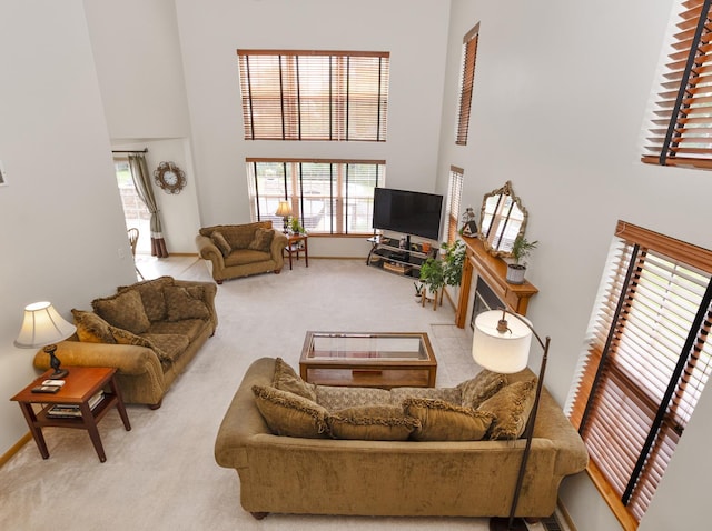 carpeted living room with a towering ceiling and baseboards