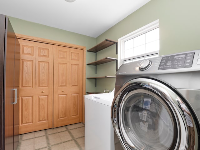 laundry room featuring light tile patterned floors and washer and clothes dryer