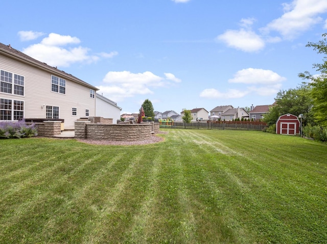 view of yard featuring an outbuilding, fence, and a storage shed