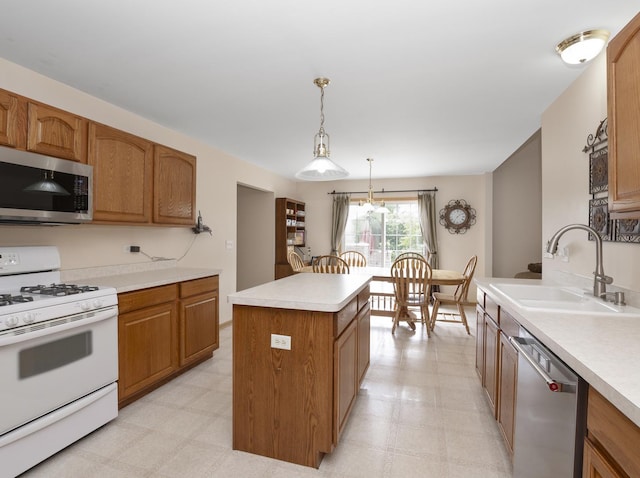 kitchen with light floors, stainless steel appliances, light countertops, a sink, and a kitchen island