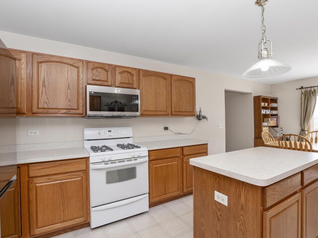 kitchen featuring white range with gas stovetop, a kitchen island, and pendant lighting