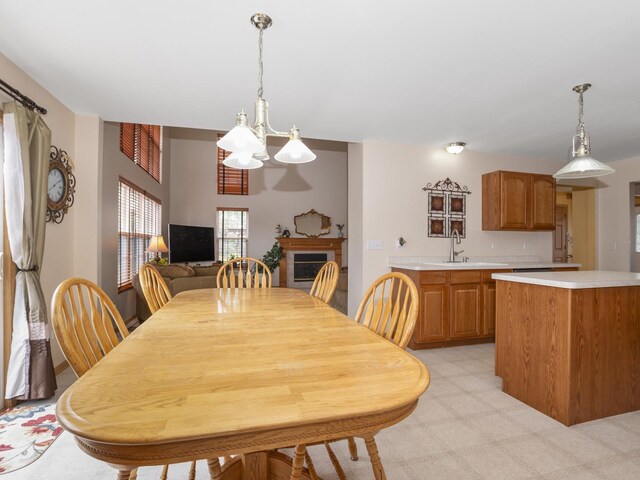 dining room featuring a notable chandelier, sink, and light colored carpet