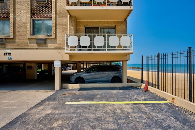 view of parking / parking lot with a beach view and a water view