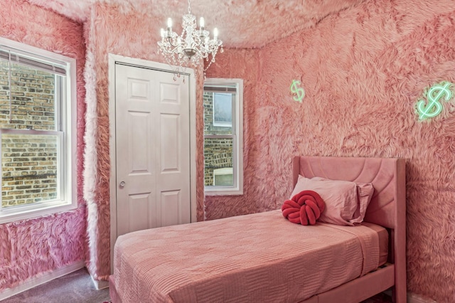 carpeted bedroom featuring a notable chandelier