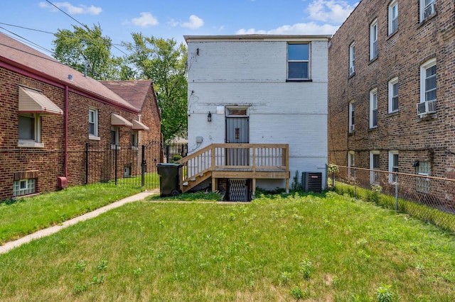 back of house featuring cooling unit, a yard, and a deck