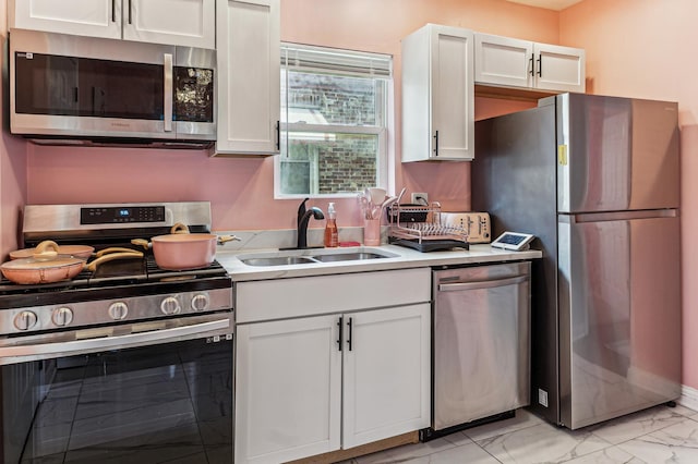 kitchen with appliances with stainless steel finishes, sink, and white cabinets