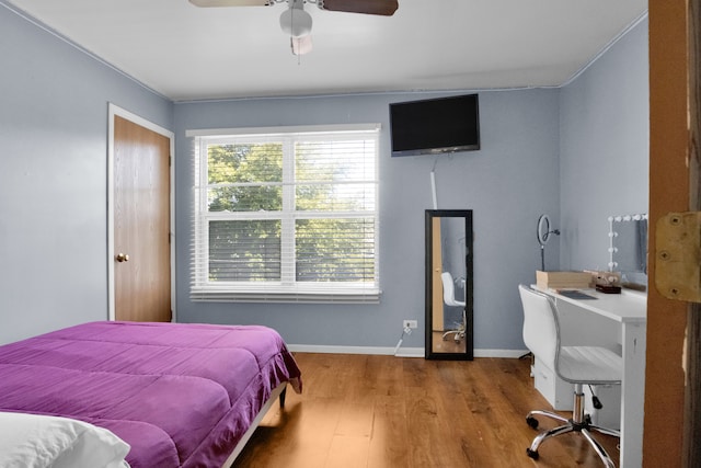 bedroom with ceiling fan, hardwood / wood-style floors, and crown molding