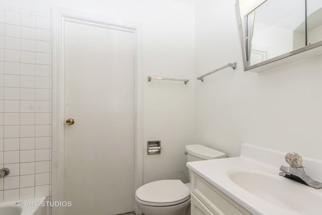 bathroom with a washtub, toilet, and vanity