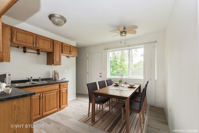 kitchen featuring ceiling fan, sink, and light hardwood / wood-style floors