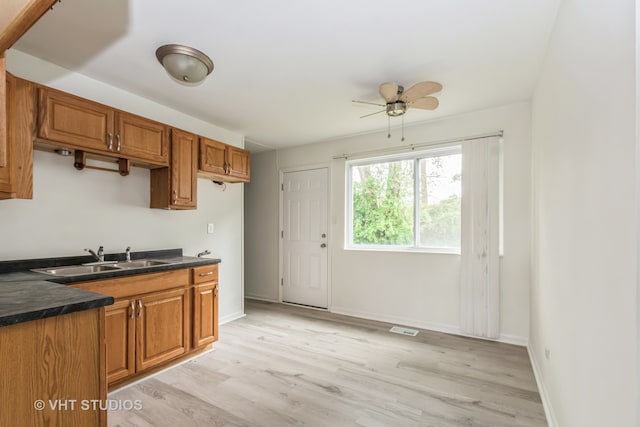 kitchen with ceiling fan, sink, and light hardwood / wood-style floors