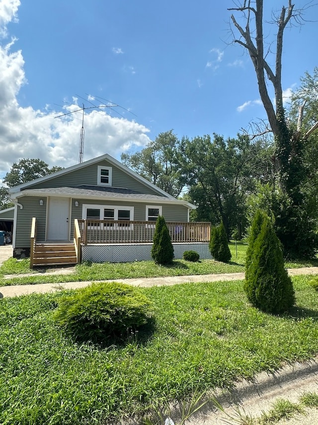 view of front of property featuring a front lawn and a wooden deck