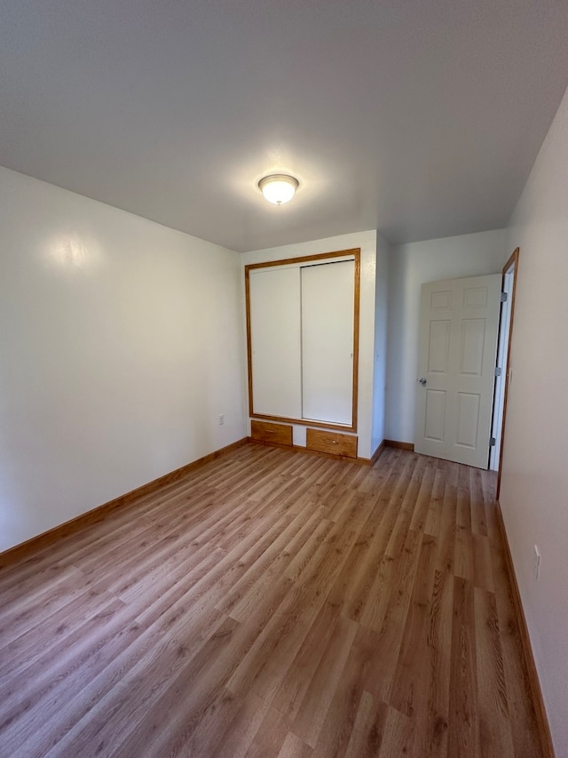 unfurnished bedroom featuring a closet and hardwood / wood-style floors