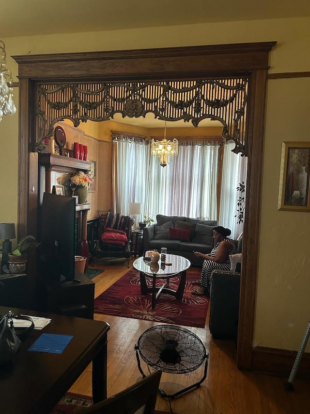 living room featuring an inviting chandelier and wood-type flooring