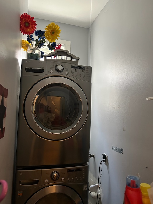 clothes washing area featuring stacked washing maching and dryer