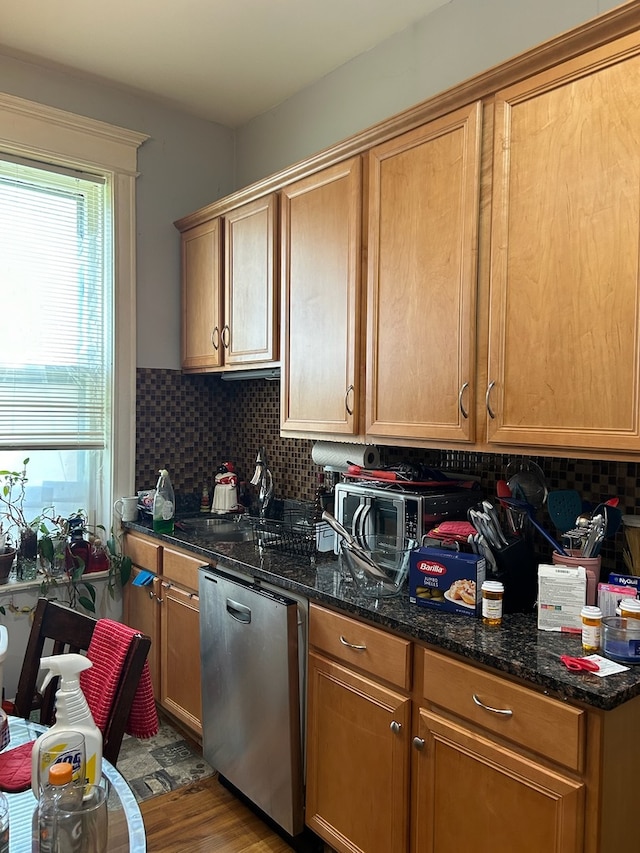 kitchen featuring dark stone counters, dishwasher, wood-type flooring, and tasteful backsplash