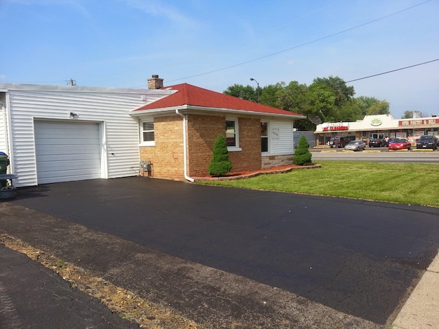 single story home with a garage and a front lawn