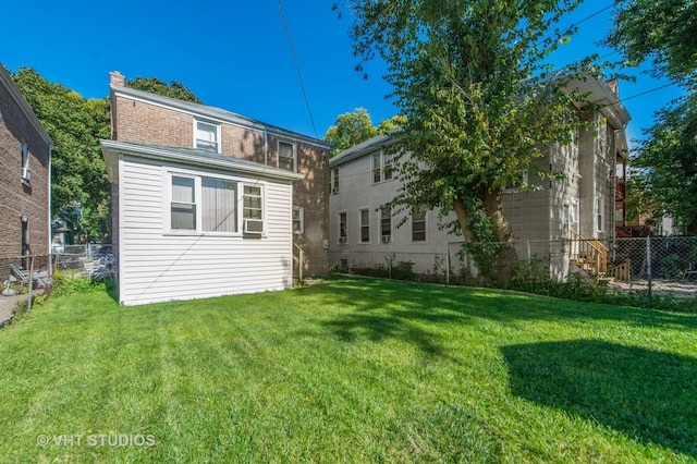 rear view of property with cooling unit and a lawn