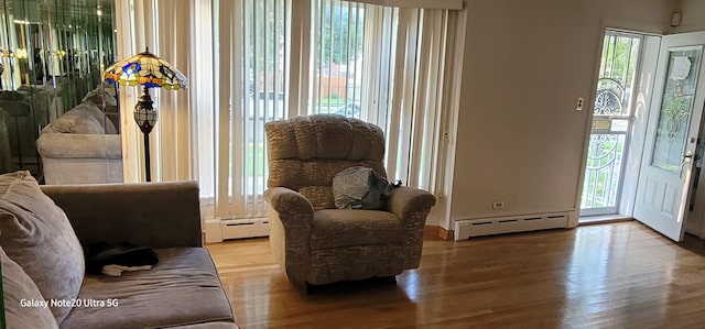 living area with hardwood / wood-style flooring and a baseboard radiator