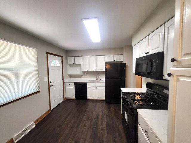 kitchen featuring sink, dark hardwood / wood-style flooring, black appliances, and white cabinets