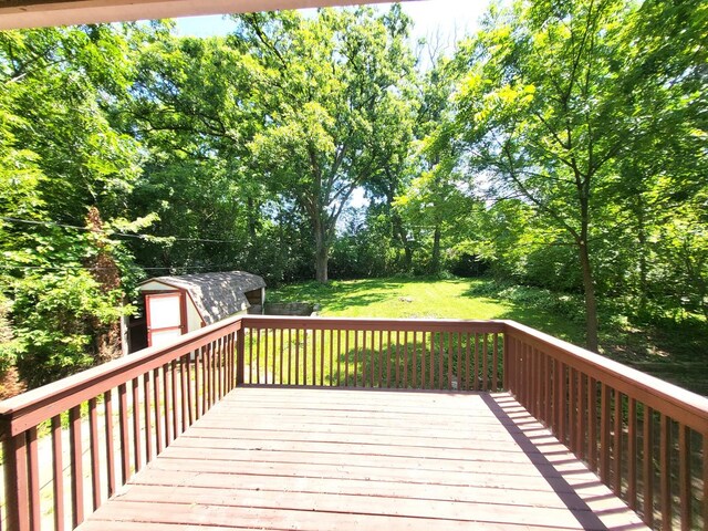 wooden deck with a storage shed and a yard