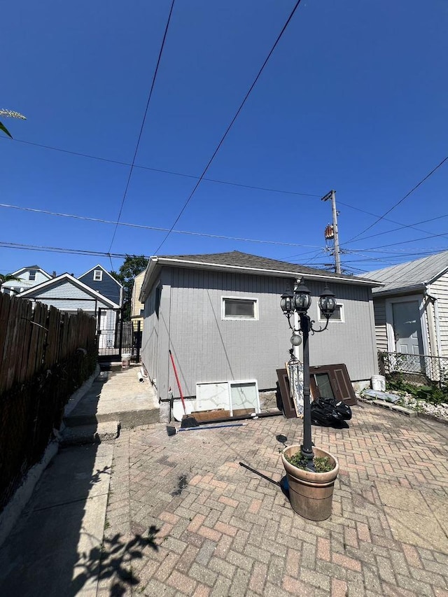 rear view of property with fence and a patio