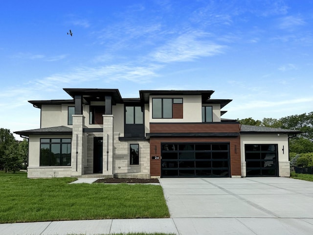 view of front of home with driveway, stone siding, a front yard, and stucco siding