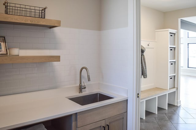 kitchen with tile patterned flooring, open shelves, a sink, and light countertops