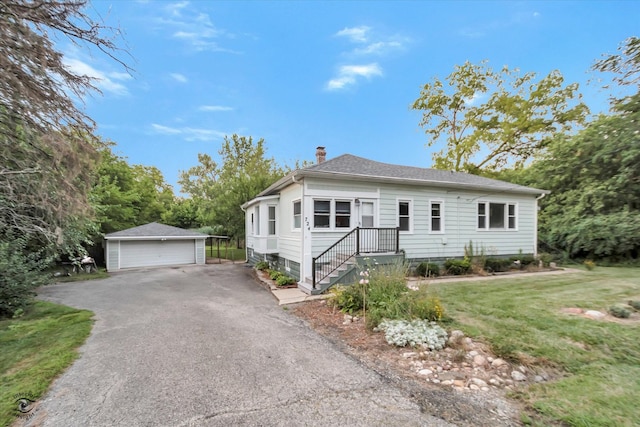 view of front facade featuring a garage, an outdoor structure, and a front lawn