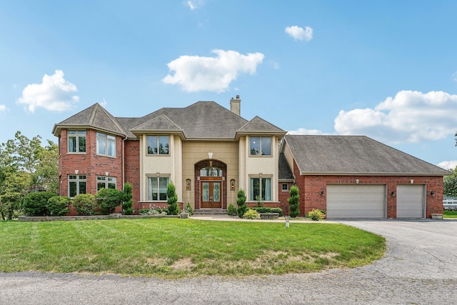 view of front of house with a garage and a front lawn