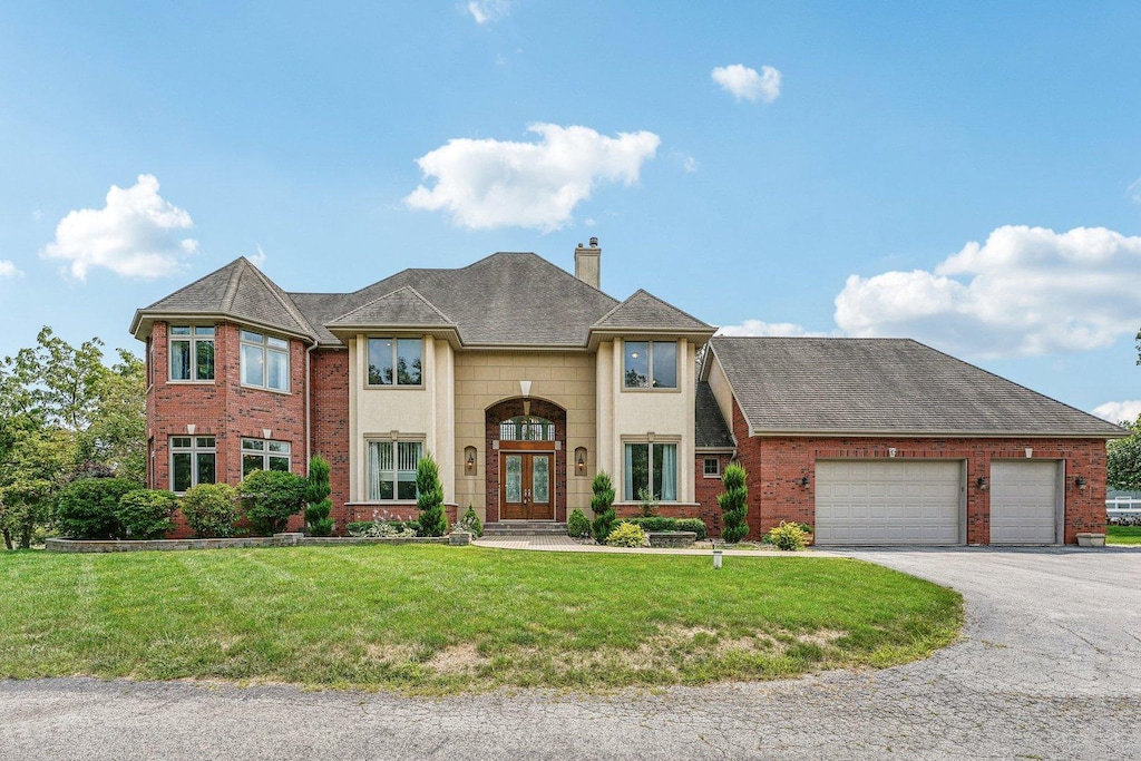 view of front of house featuring french doors, a garage, and a front yard