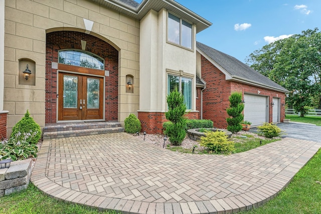 entrance to property with a garage and french doors