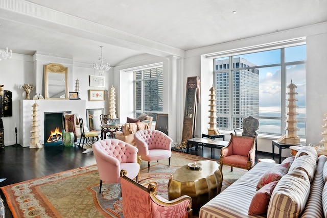 living room with an inviting chandelier, a water view, and dark hardwood / wood-style flooring