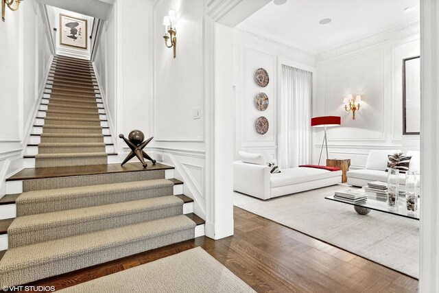 foyer with dark wood-type flooring and ornamental molding