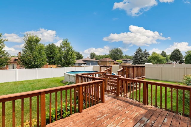 deck featuring a fenced in pool and a lawn