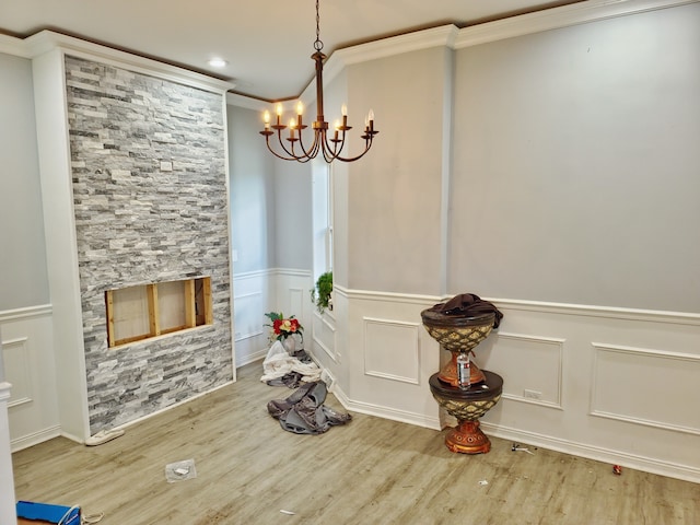 dining area featuring an inviting chandelier, wood-type flooring, and ornamental molding