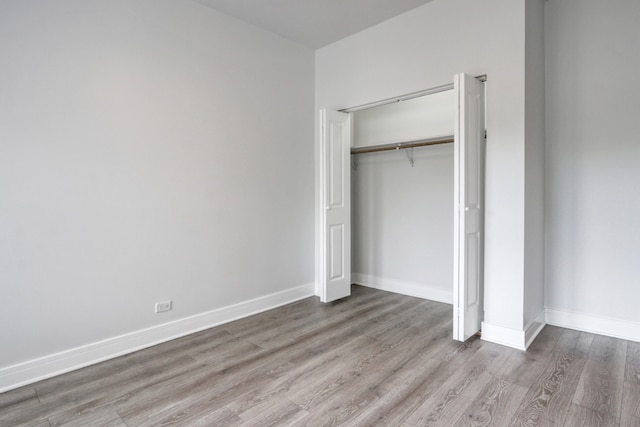 unfurnished bedroom featuring hardwood / wood-style flooring and a closet