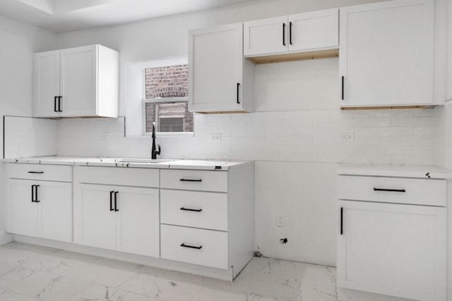 kitchen with light tile patterned flooring, sink, decorative backsplash, and white cabinets