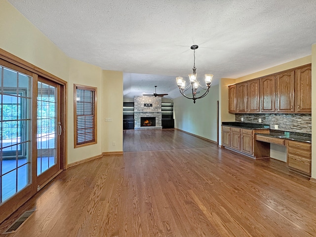 kitchen with hardwood / wood-style floors, tasteful backsplash, and a fireplace