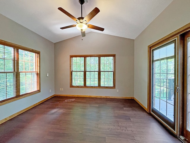 empty room with ceiling fan, dark wood-type flooring, lofted ceiling, and a healthy amount of sunlight