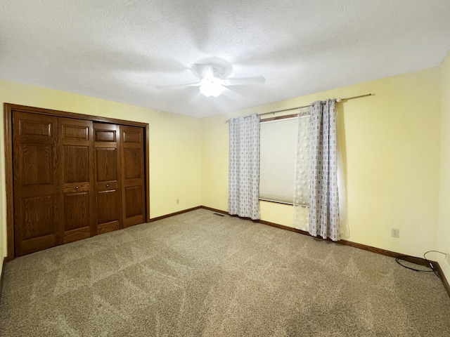 unfurnished bedroom featuring ceiling fan, carpet flooring, a textured ceiling, and a closet