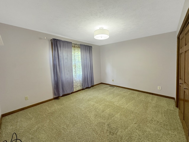 carpeted spare room featuring a textured ceiling