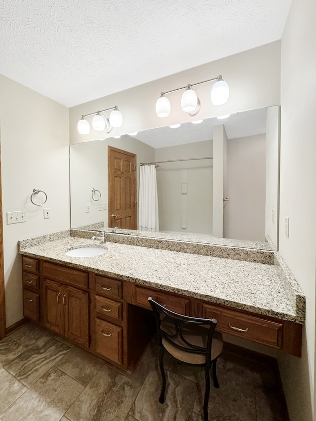 bathroom with a textured ceiling, vanity, and tile patterned flooring