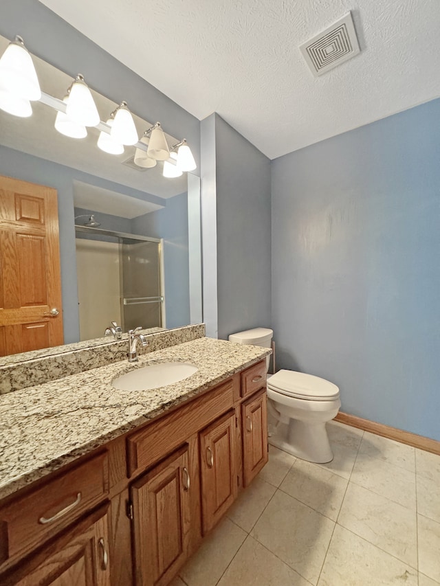 bathroom featuring tile patterned floors, vanity, a textured ceiling, and toilet