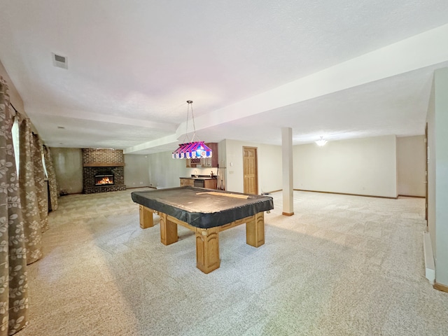 playroom with a brick fireplace, brick wall, light carpet, and billiards