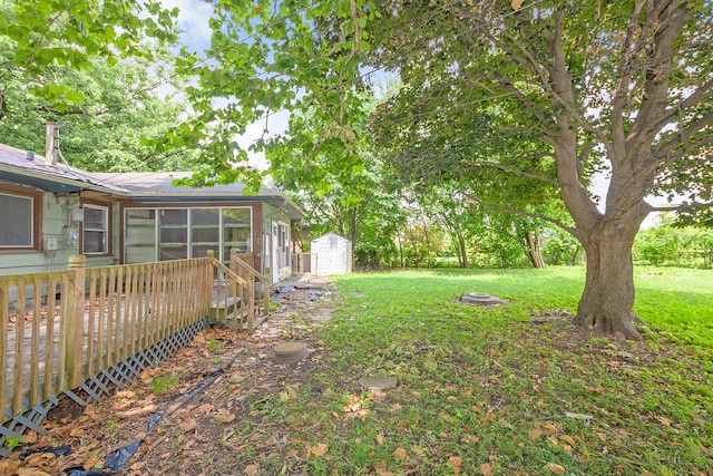 view of yard featuring a storage unit, a wooden deck, and an outdoor fire pit