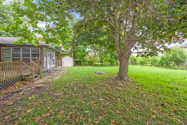 view of yard featuring a storage shed, a sunroom, and a fire pit